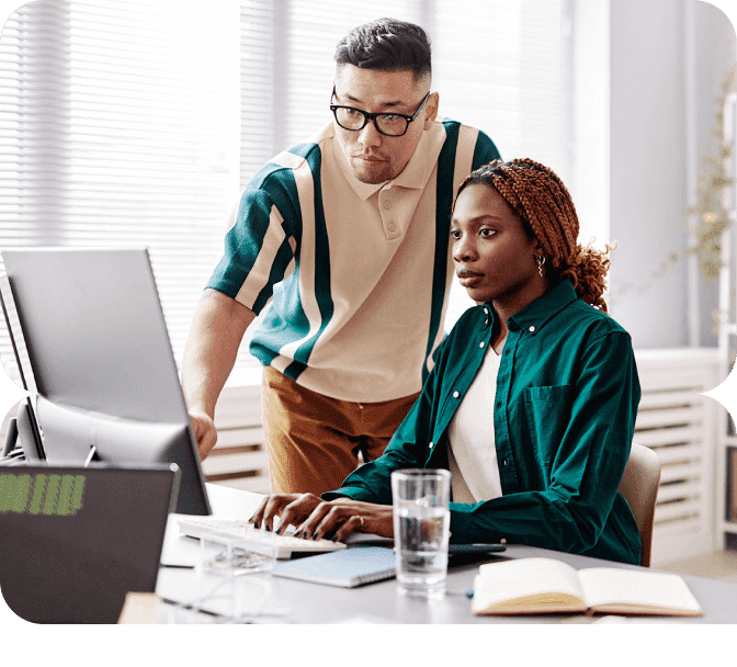 A man and woman working together on a computer.